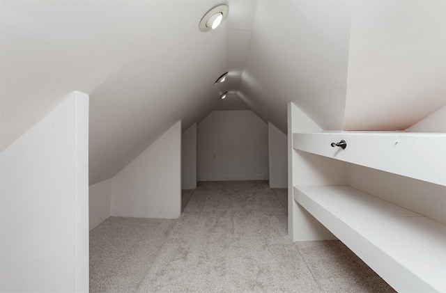 additional living space with light colored carpet and lofted ceiling