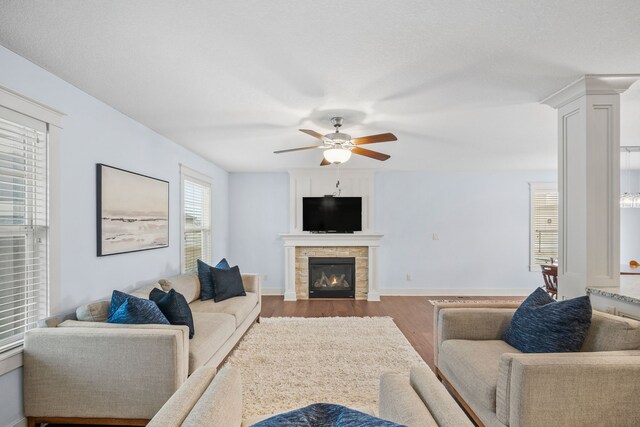 living room featuring ceiling fan, hardwood / wood-style floors, and a fireplace