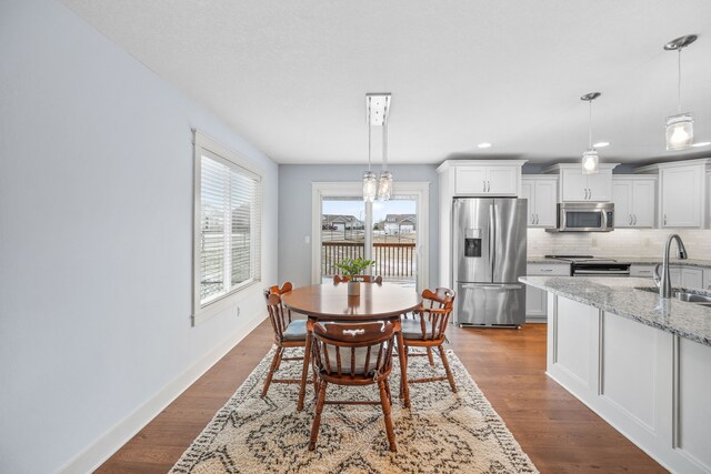 dining space with hardwood / wood-style flooring and sink