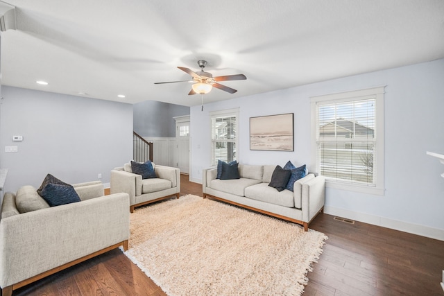 living room featuring ceiling fan and dark hardwood / wood-style floors