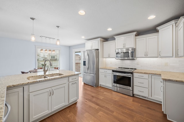 kitchen with white cabinetry, stainless steel appliances, pendant lighting, and sink