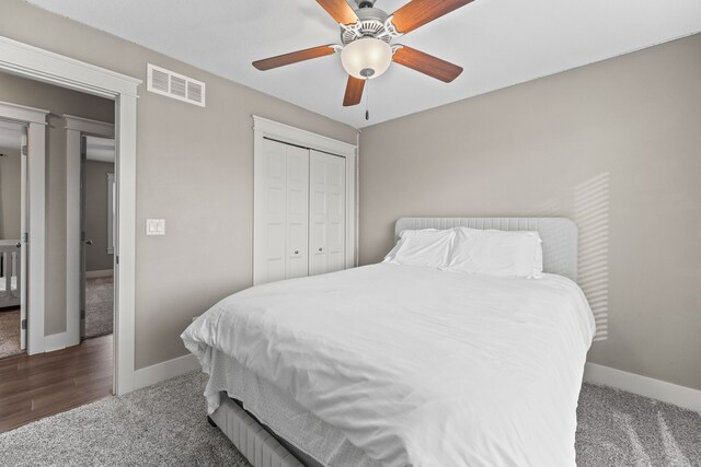 bedroom with dark colored carpet, ceiling fan, and a closet