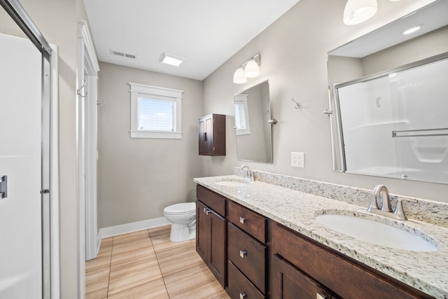 bathroom with vanity, toilet, a shower with shower door, and tile patterned flooring