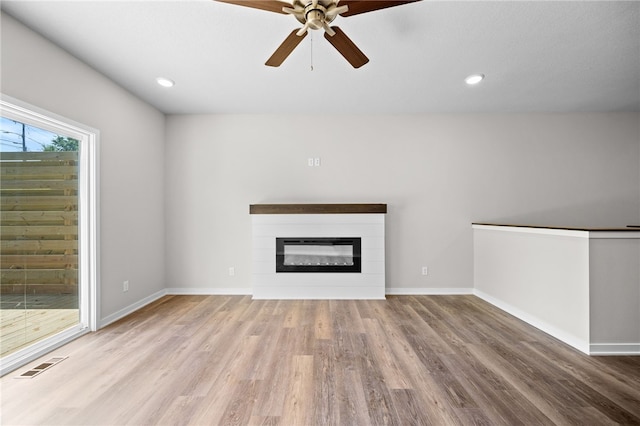 unfurnished living room featuring ceiling fan and light wood-type flooring