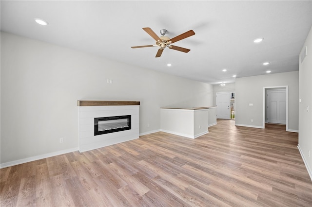 unfurnished living room featuring ceiling fan and light hardwood / wood-style flooring