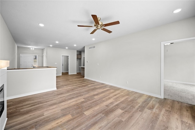 unfurnished living room featuring hardwood / wood-style floors and ceiling fan