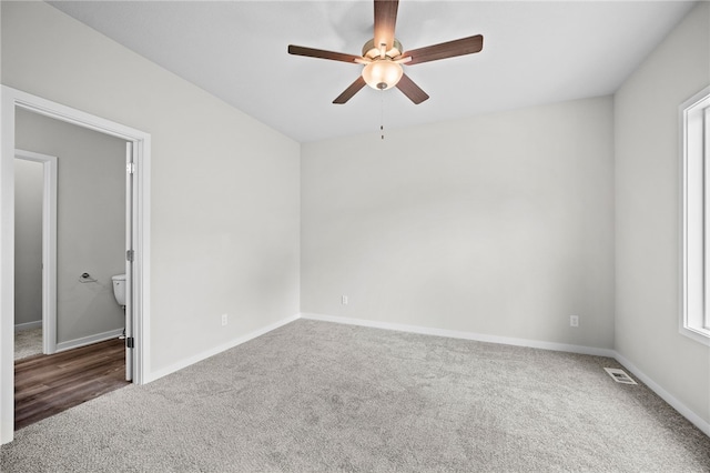 carpeted spare room featuring ceiling fan