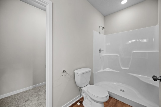 bathroom featuring walk in shower and toilet