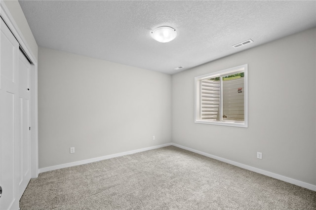 unfurnished bedroom with carpet floors, a closet, and a textured ceiling