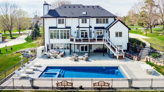 rear view of house featuring outdoor lounge area, a pool side deck, a yard, and a patio area