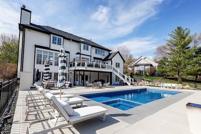 back of house featuring a pool with hot tub, an outdoor hangout area, and a patio area