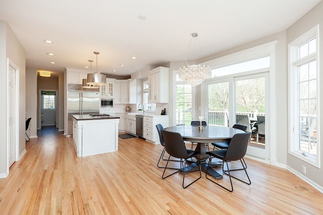 dining area with sink, a chandelier, and light hardwood / wood-style floors