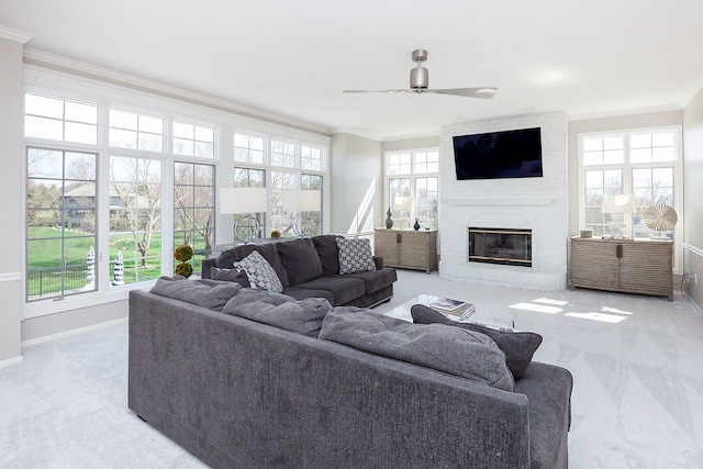 living room with light colored carpet, ornamental molding, a fireplace, and a wealth of natural light