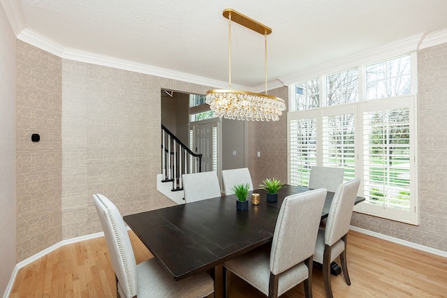 dining room featuring hardwood / wood-style flooring, crown molding, and a notable chandelier