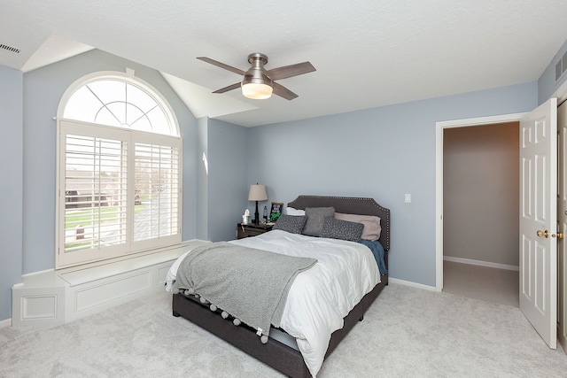 carpeted bedroom featuring ceiling fan, vaulted ceiling, and multiple windows