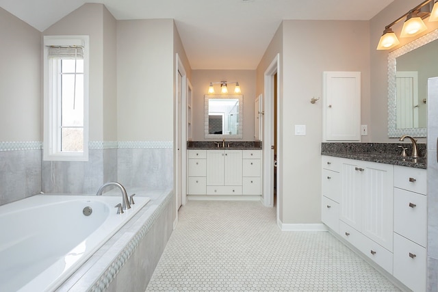 bathroom featuring vanity and tiled bath