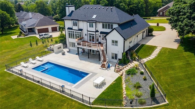 back of property featuring a pool side deck, a lawn, and a patio