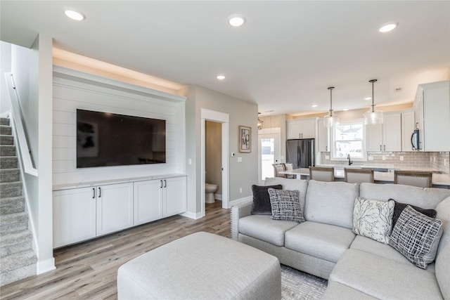 living room featuring sink and light hardwood / wood-style floors