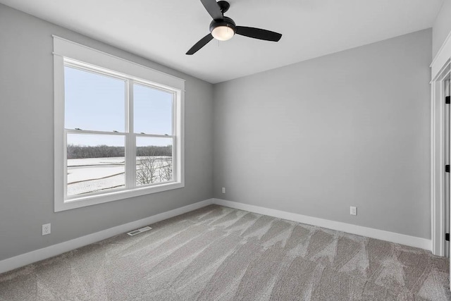 carpeted spare room featuring ceiling fan