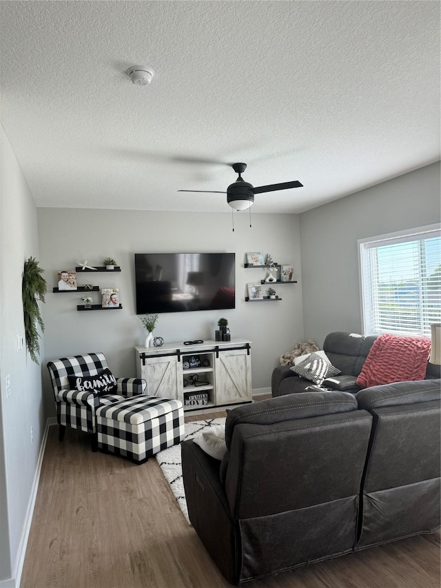 living room with wood-type flooring, a textured ceiling, and ceiling fan