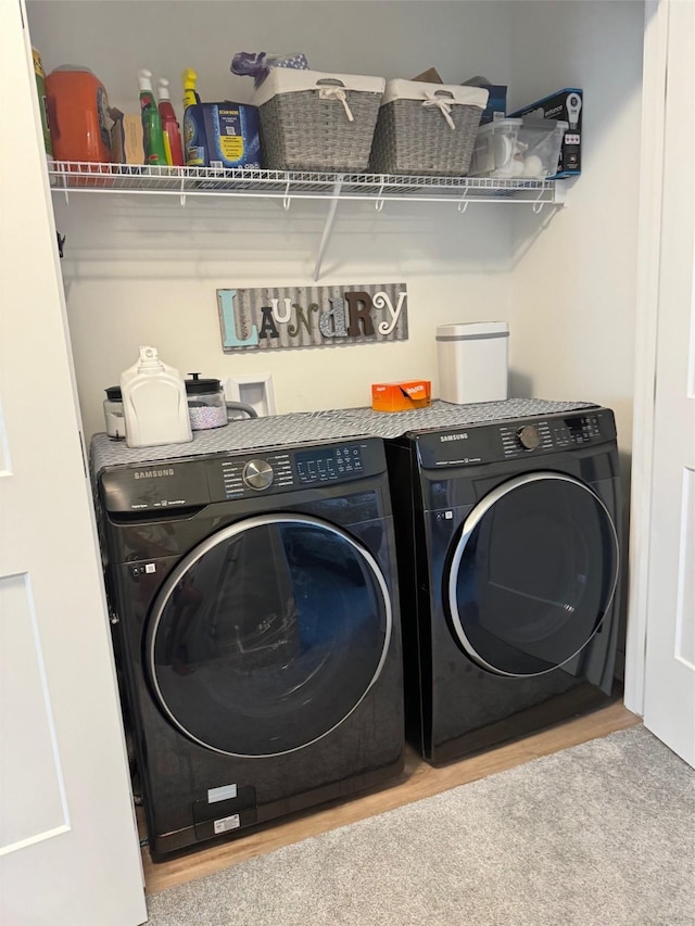 clothes washing area featuring wood-type flooring and washer and dryer