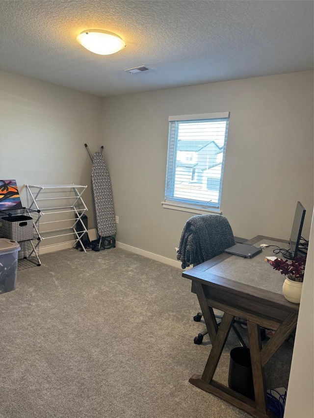 carpeted office featuring a textured ceiling