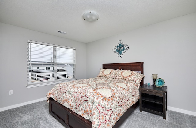 bedroom featuring carpet floors and a textured ceiling