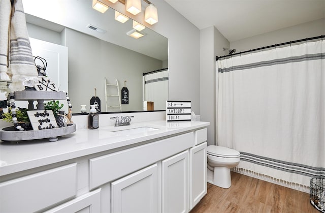 bathroom featuring vanity, hardwood / wood-style flooring, and toilet