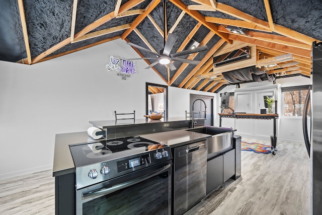 kitchen with lofted ceiling, stainless steel appliances, sink, and light hardwood / wood-style flooring