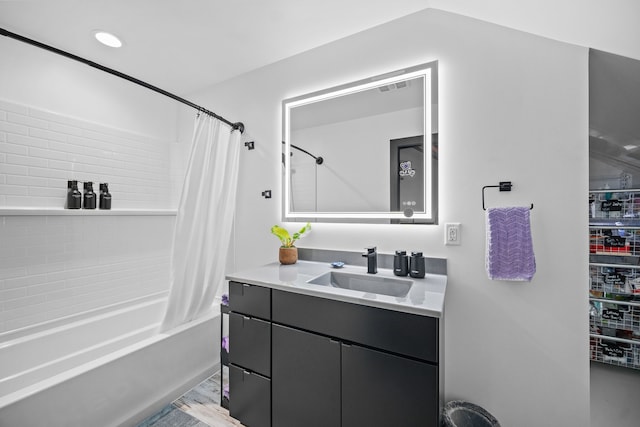 bathroom with hardwood / wood-style flooring, shower / bath combo, and vanity