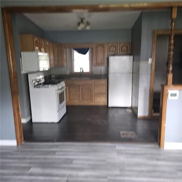 kitchen featuring hardwood / wood-style flooring, white appliances, and sink