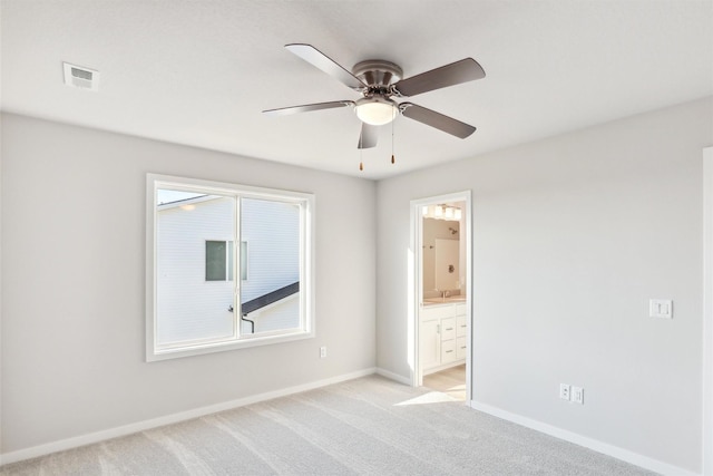 spare room featuring ceiling fan, light colored carpet, and sink