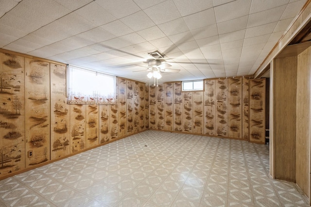 basement with plenty of natural light and wood walls