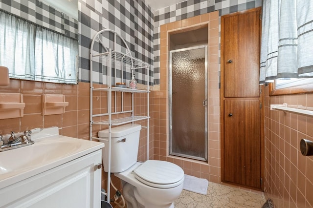 bathroom featuring vanity, toilet, an enclosed shower, and tile walls