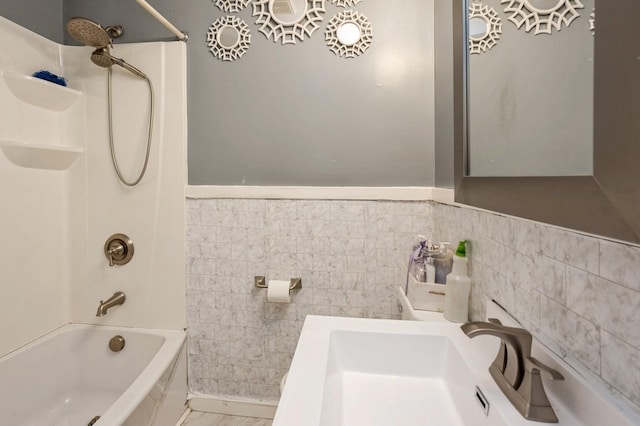 bathroom featuring tile walls, sink, and shower / tub combination