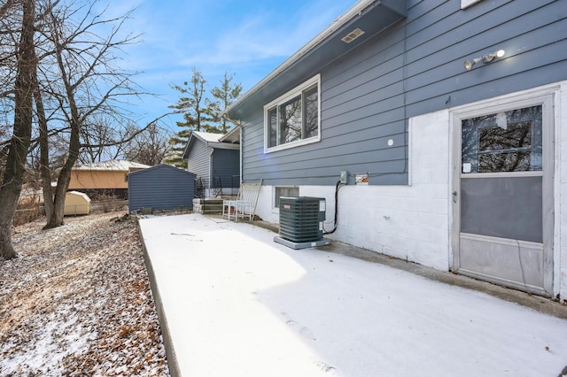 snow covered patio with central AC unit