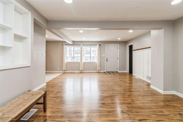 unfurnished living room featuring hardwood / wood-style floors and beamed ceiling