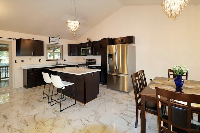 kitchen featuring pendant lighting, lofted ceiling, an inviting chandelier, stainless steel appliances, and a kitchen island