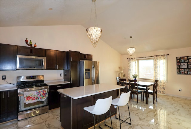 kitchen with a breakfast bar area, a center island, appliances with stainless steel finishes, a notable chandelier, and pendant lighting