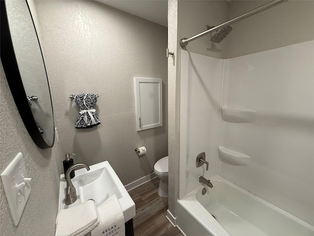 full bathroom featuring hardwood / wood-style flooring, sink, shower / bathtub combination, and toilet