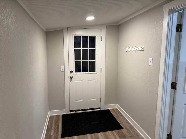 entryway with ornamental molding and dark hardwood / wood-style floors