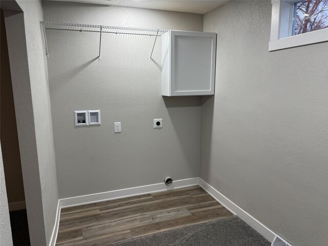 clothes washing area featuring dark wood-style floors, hookup for an electric dryer, laundry area, hookup for a washing machine, and baseboards