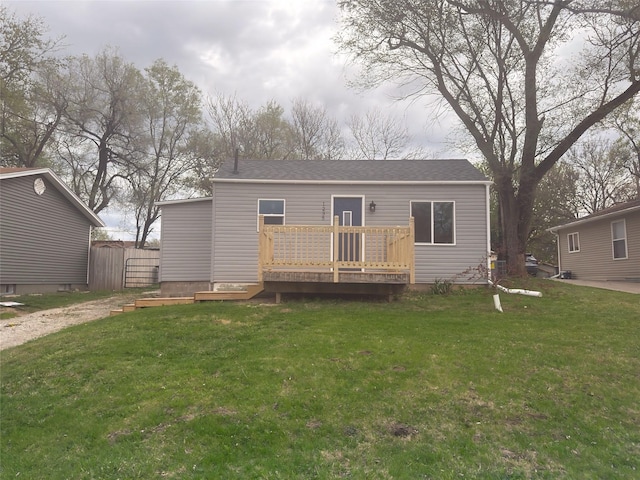 back of house with a wooden deck and a lawn