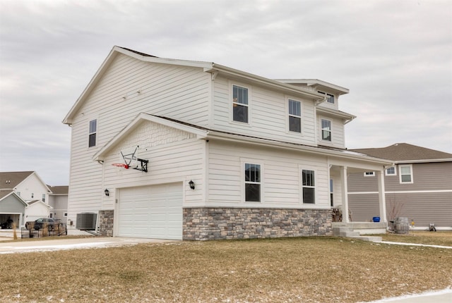 view of front facade with a garage, central AC, and a front lawn