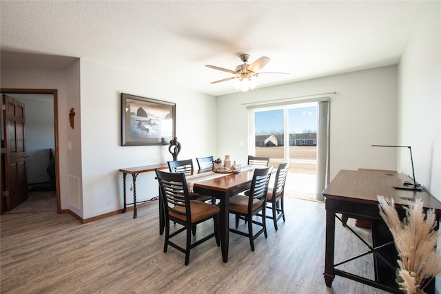 dining room featuring hardwood / wood-style floors, a textured ceiling, and ceiling fan