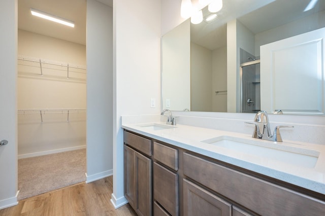 bathroom featuring hardwood / wood-style flooring, vanity, and a shower with shower door