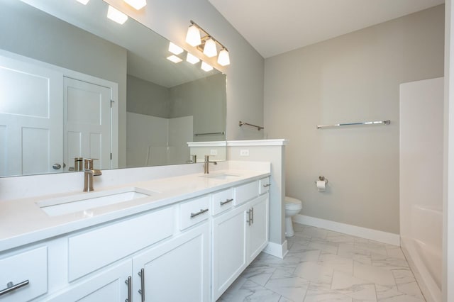 bathroom with walk in shower, vanity, and toilet