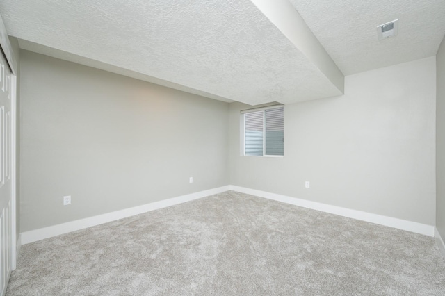 interior space featuring light colored carpet and a textured ceiling