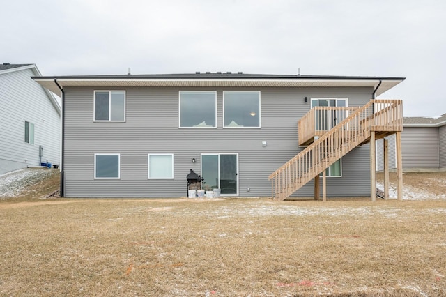 back of property featuring a wooden deck and a yard