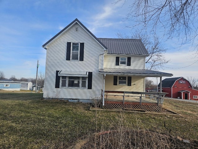 back of house with a porch, an outdoor structure, and a lawn